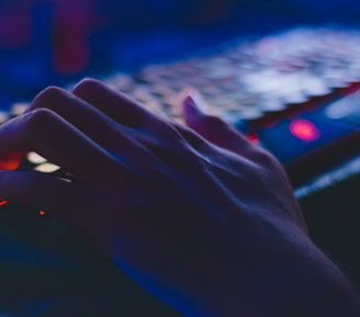 a hand typing on a backlit keyboard