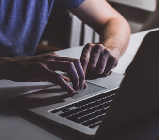 A dubious person sitting in front of a laptop computer