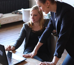 Two people working over a computer together