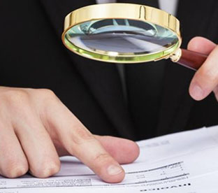 Someone scanning a document with a magnifying glass